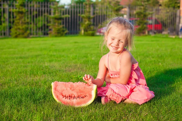 Piccola ragazza sorridente con un pezzo di anguria in mano — Foto Stock