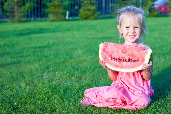 Piccola ragazza divertente adorabile con un pezzo di anguria in mano — Foto Stock