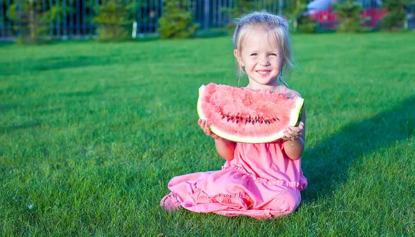 Pequeña chica divertida adorable con un pedazo de sandía en las manos —  Fotos de Stock