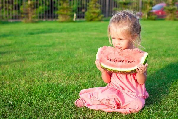 Kleines Mädchen isst im Sommer eine reife saftige Wassermelone — Stockfoto