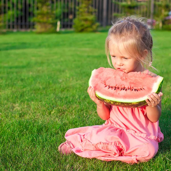 Menina comendo uma melancia suculenta madura no verão — Fotografia de Stock