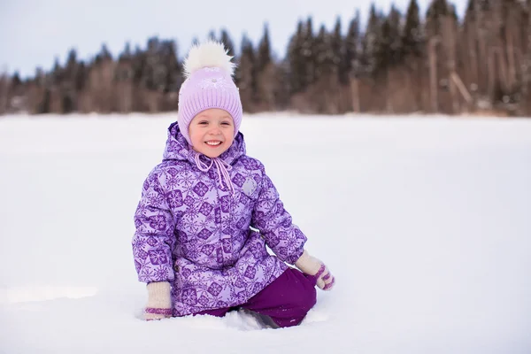 Niña adorable sentada en la nieve en invierno día soleado —  Fotos de Stock