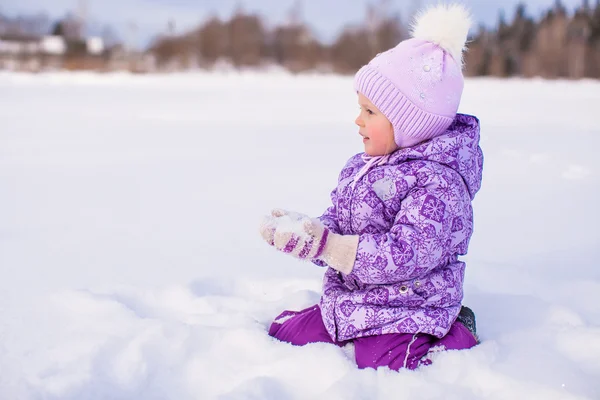 Happy little girl playing with snow at winter sunny day — Stock Photo, Image