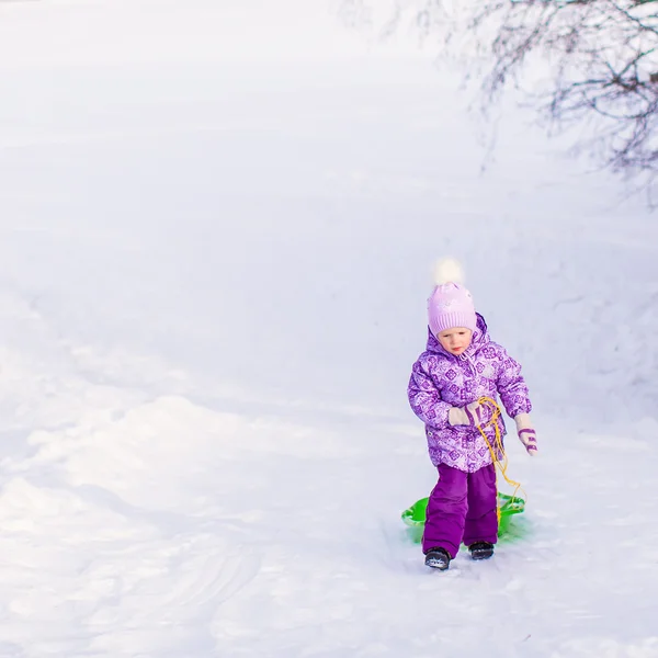 小女孩拉着雪橇在温暖的冬日 — 图库照片