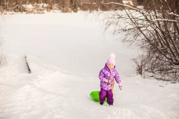 Niña tira de un trineo en el cálido día de invierno —  Fotos de Stock