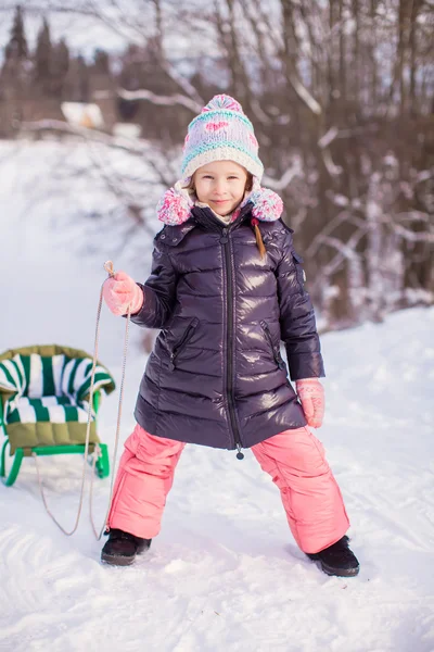 Little girl goes sledding on a warm winter day — Stock Photo, Image