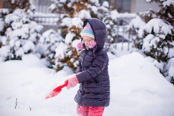 Bambina che gioca con la pala rossa in giardino — Foto Stock