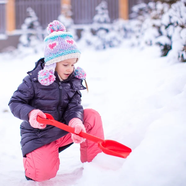 Dziewczyna pobawic śniegu łopatą na zimowe wieczory — Zdjęcie stockowe