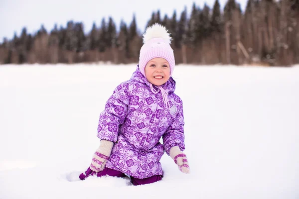 Feliz niña divirtiéndose en la nieve en invierno día soleado —  Fotos de Stock