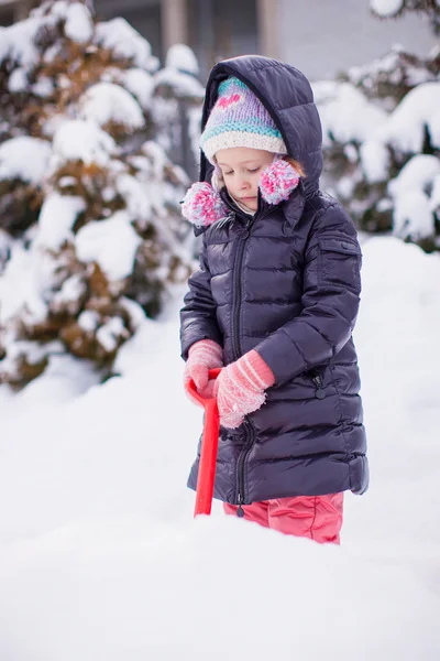 Little girl play with snow shoveling on a winter day — Stock Photo, Image