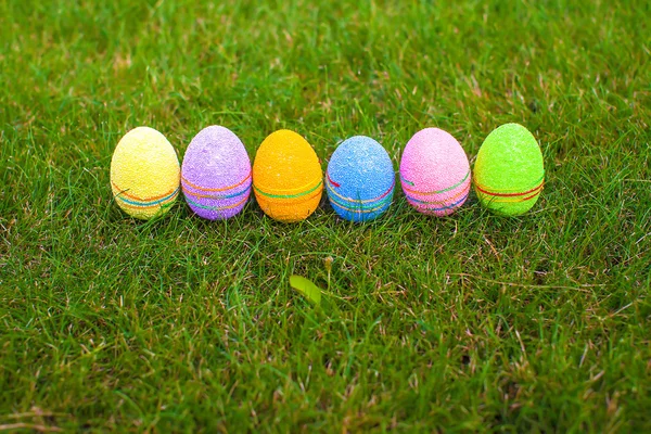 Multi-colored Easter eggs on green grass — Stock Photo, Image