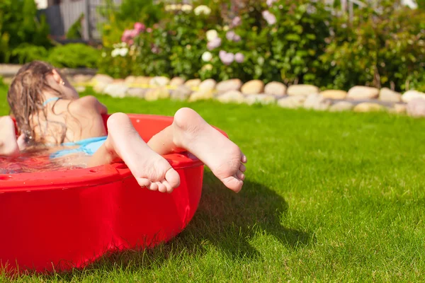 Крупный план ног маленькой девочки в бассейне — стоковое фото