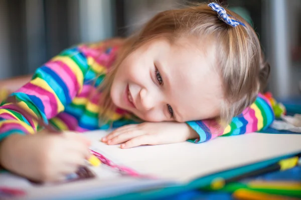 Lilla söta tjejen som målar med pennor när du sitter vid hennes bord — Stockfoto