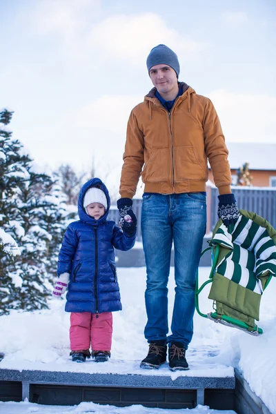 Ung pappa och lilla flickan åka pulka i en kall vinterdag — Stockfoto