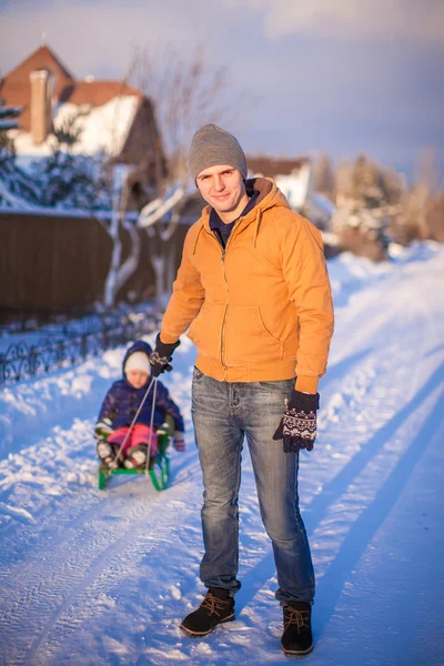 Papá joven y niña van en trineo en un frío día de invierno —  Fotos de Stock