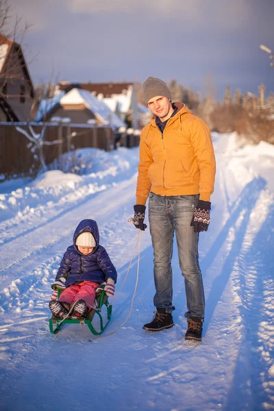 맑은 겨울 날에 그의 어린 딸을 썰매 젊은 아빠 — 스톡 사진