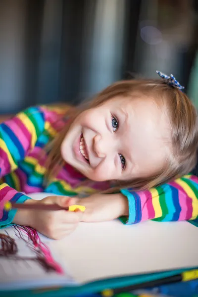 Pouco bonito menina pintura com lápis enquanto sentado em sua mesa — Fotografia de Stock