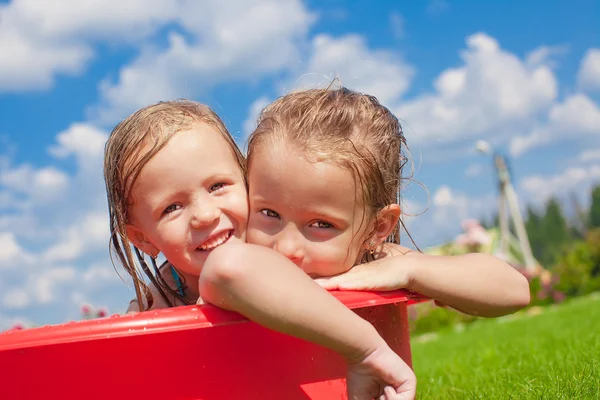 Two adorable little happy girls having fun outdoor on summer day background blue sky — Stock Photo, Image