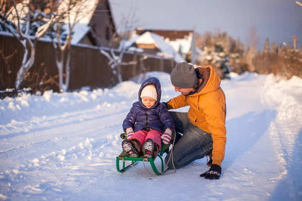 Ung pappa kälkåkning hans lilla bedårande dotter på en solig vinterdag — Stockfoto