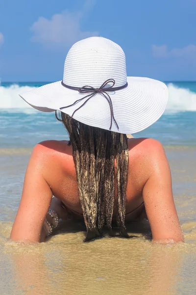 Jeune femme assise dans un chapeau blanc profitant de vacances d'été — Photo