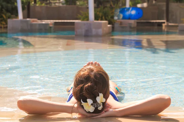 Krásná mladá dívka se těší letní dovolená v klidné luxusní bazén — Stock fotografie