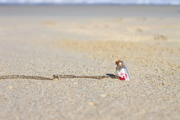 Kleine Flasche im weißen Sandstrand Hintergrund das türkisfarbene Meer — Stockfoto