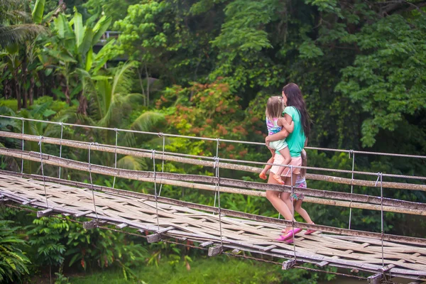 Little girls and young woman walking on suspension bridge over the River Loboc, Philippines — Stock Photo, Image