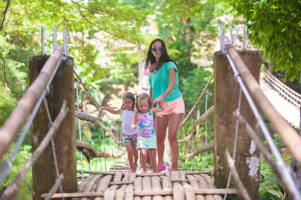 Jovem mãe com suas meninas na ponte suspensa sobre o rio Loboc, Filipinas — Fotografia de Stock