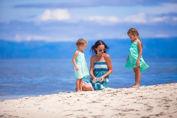 Adorable little girls and young mother relax on tropical white beach in desert island — Stock Photo, Image
