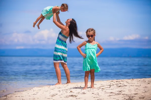 Giovane madre felice e le sue adorabili figlie si divertono sulla spiaggia esotica nella giornata di sole — Foto Stock