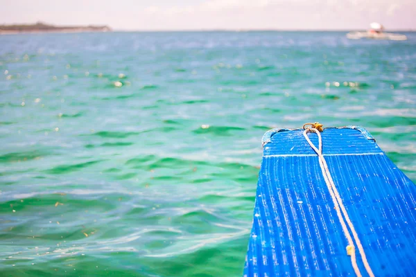 Petit bateau bleu en pleine mer sur une île déserte — Photo