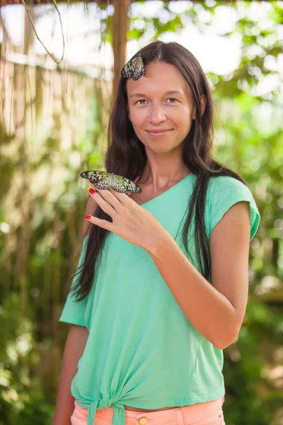 Mladá žena s motýly v přírodní zahradě — Stock fotografie