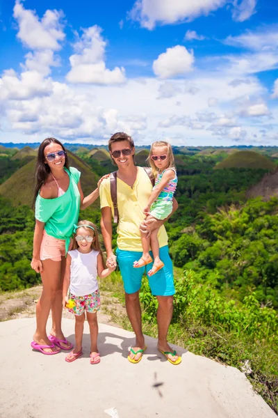 Young family of four on a background the Chocolate Hills in Bohol — Stock Photo, Image