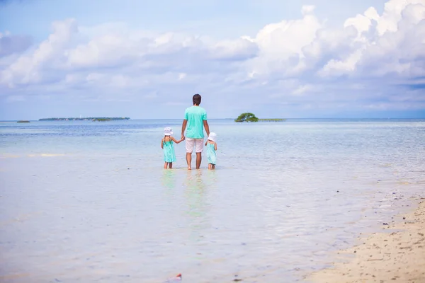 Back view of adorable little girls and young father walking at exotic island — Stock Photo, Image