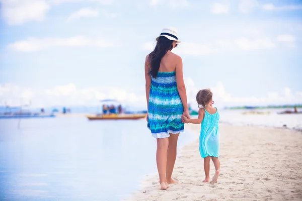 Indietro vista della madre e la sua piccola figlia a piedi dal mare — Foto Stock