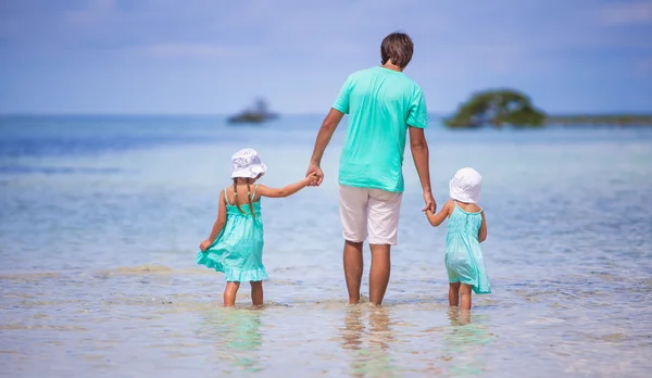 Vista trasera del joven padre y sus dos hijos pequeños caminando por el mar —  Fotos de Stock