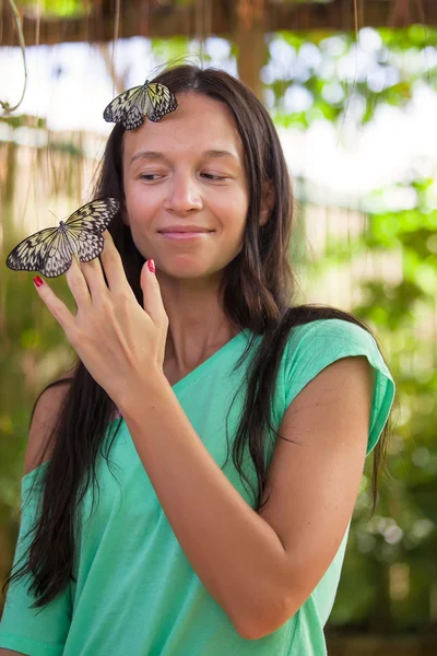 Giovane ragazza che guarda le farfalle in un giardino naturale — Foto Stock