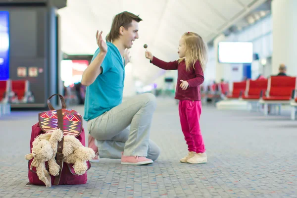 Klein schattig meisje en jonge vader in de luchthaven — Stockfoto