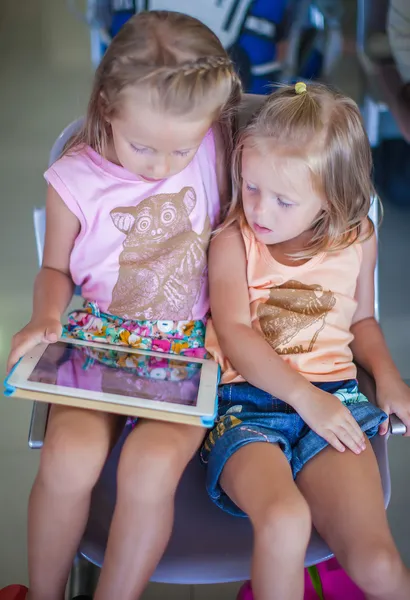 Adorable Little girl in the airport looking at laptop while waiting for flight — Stock Photo, Image