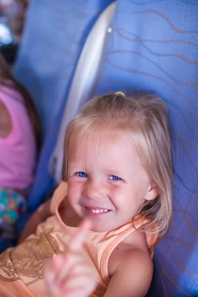 Kleines lächelndes glückliches Mädchen im Flugzeug — Stockfoto