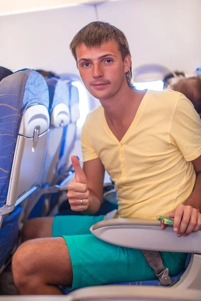 Jonge man in een vliegtuig verschijnt thums — Stockfoto