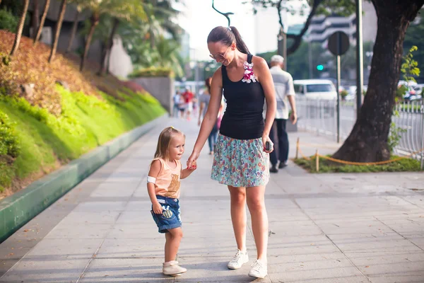 年轻的妈妈和小女孩在一个大城市的户外走 — 图库照片