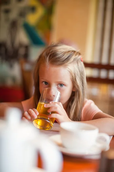 Entzückendes kleines Mädchen frühstückt und trinkt Fruchtcocktail — Stockfoto