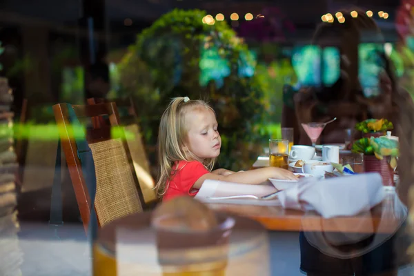 Adorable little girl in a beautiful cafe outside the window — Stock Photo, Image