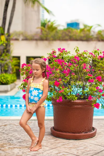 Petite fille près de la piscine en plein air dans un complexe de luxe — Photo