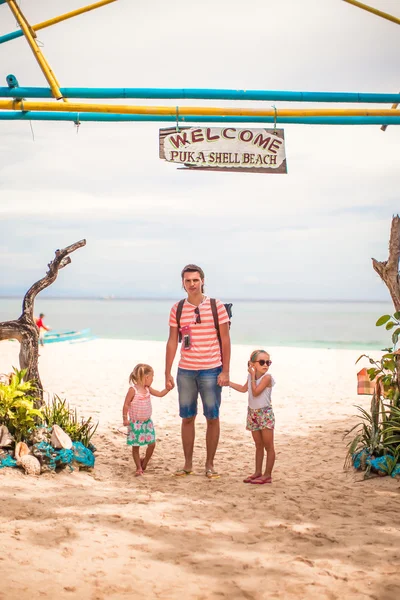 Little girls and young dad walking on a tropical beach — Stock Photo, Image