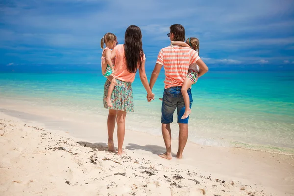 Familia vista trasera de cuatro en vacaciones en la playa — Foto de Stock