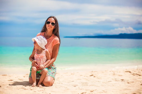 Roztomilá holčička, baví se svou matkou na bílé písečné pláži — Stock fotografie