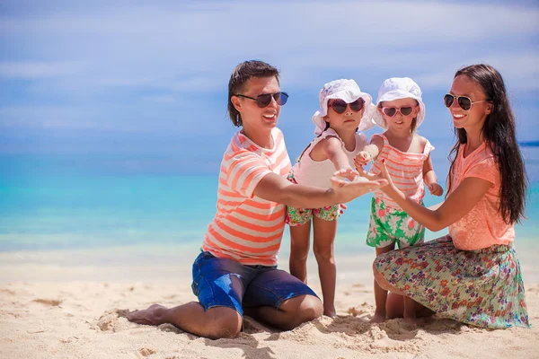 Nuori kaunis neljän hengen perhe nautti rentouttavasta rannalla — kuvapankkivalokuva