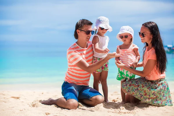 Молода красива сім'я з чотирьох насолоджувалася відпочинком на пляжі — стокове фото